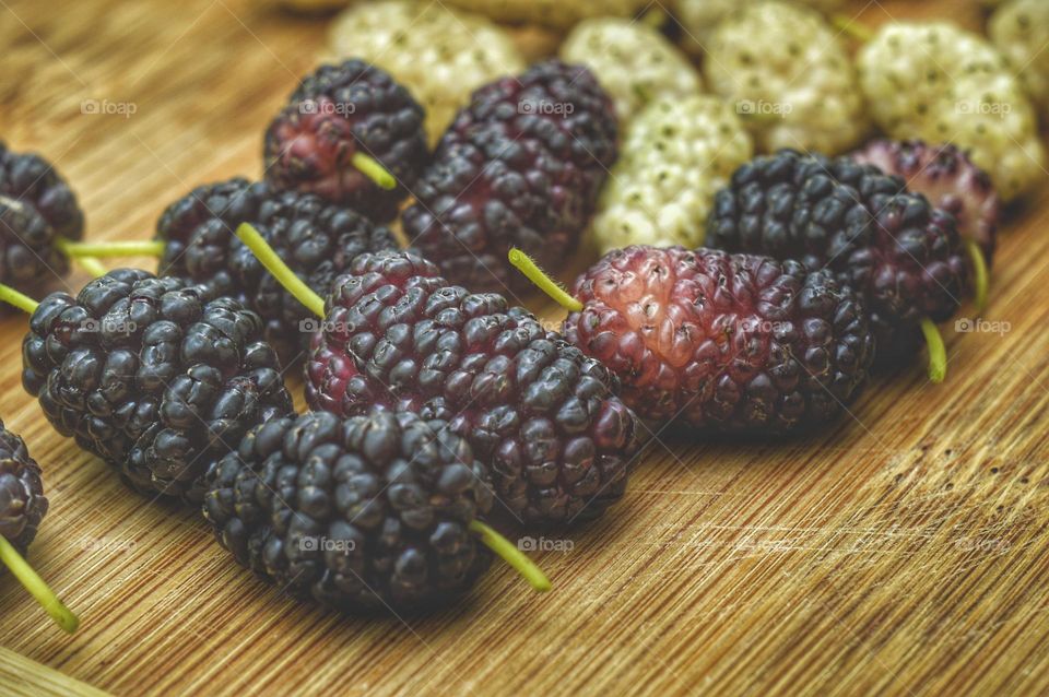 several black and white mulberry berries on the kitchen table close up photo