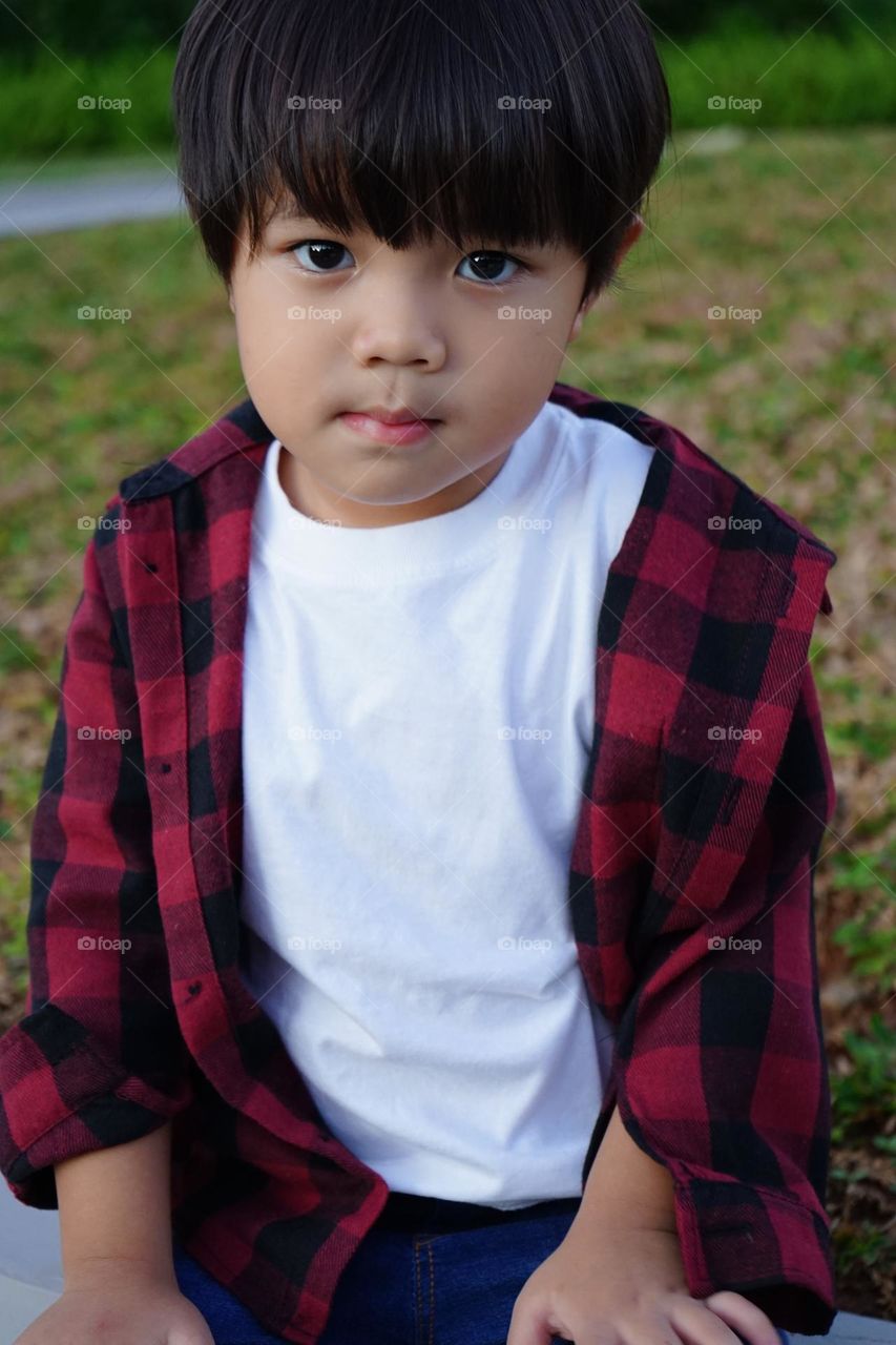 Cute Asian boy posing at garden