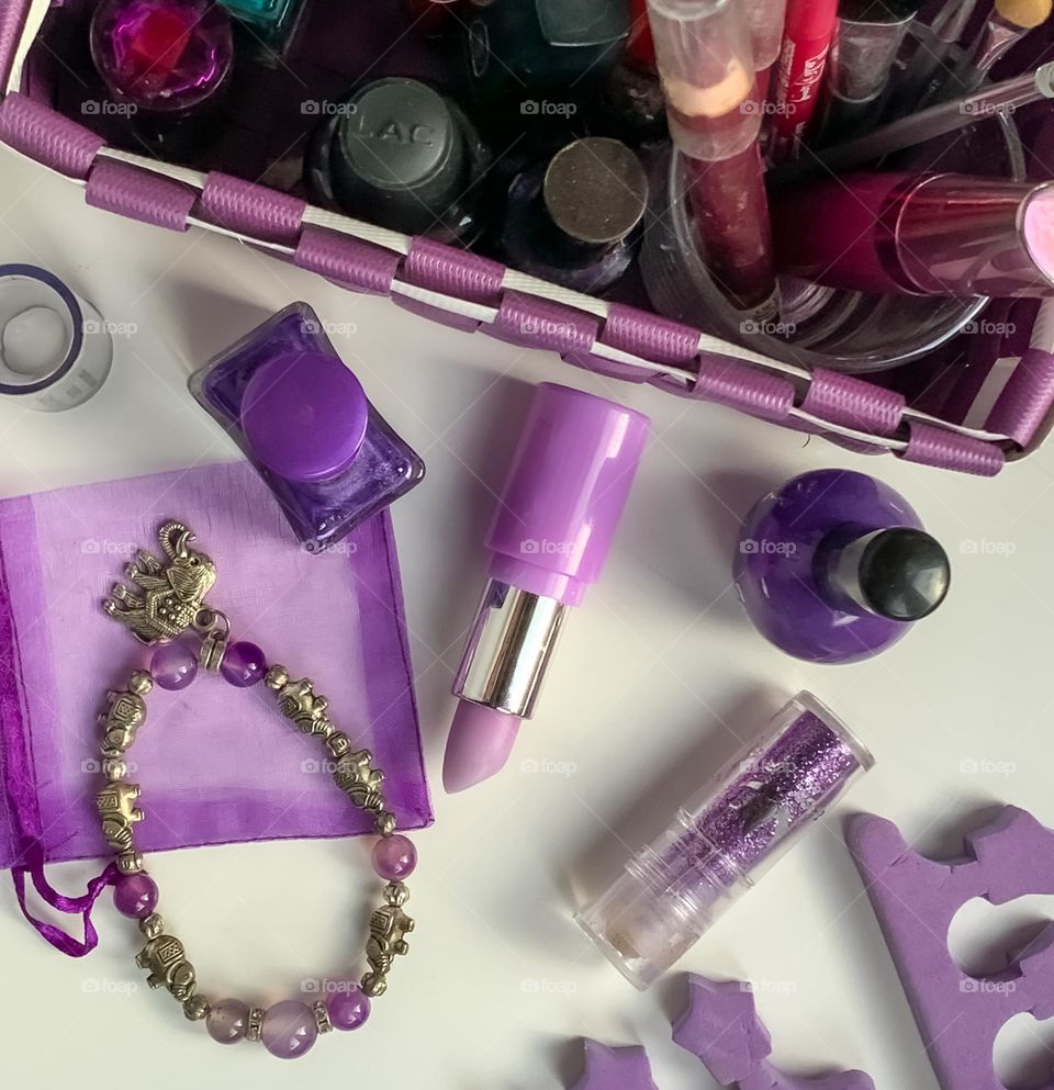 Flat lay of assorted make up with pinky/purple theme