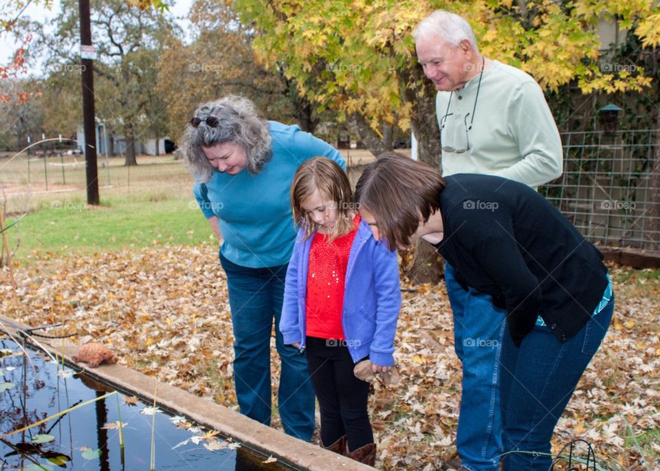 People staring in a pond