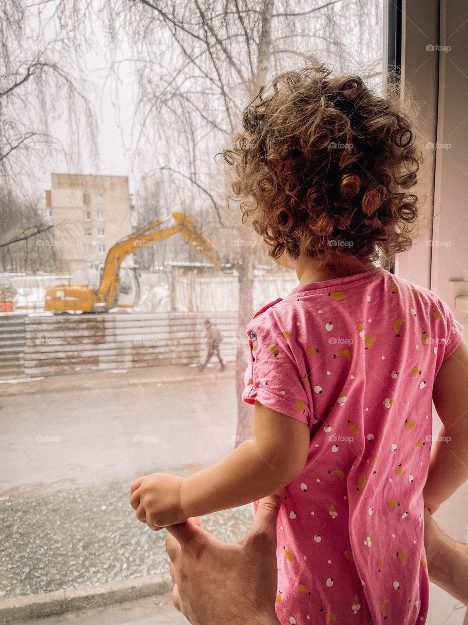 Baby girl looking through the window