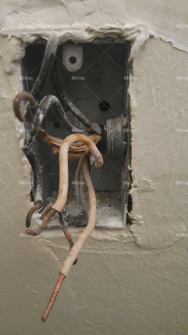close up view of shorted out electrical junction box with exposed electrical wiring.