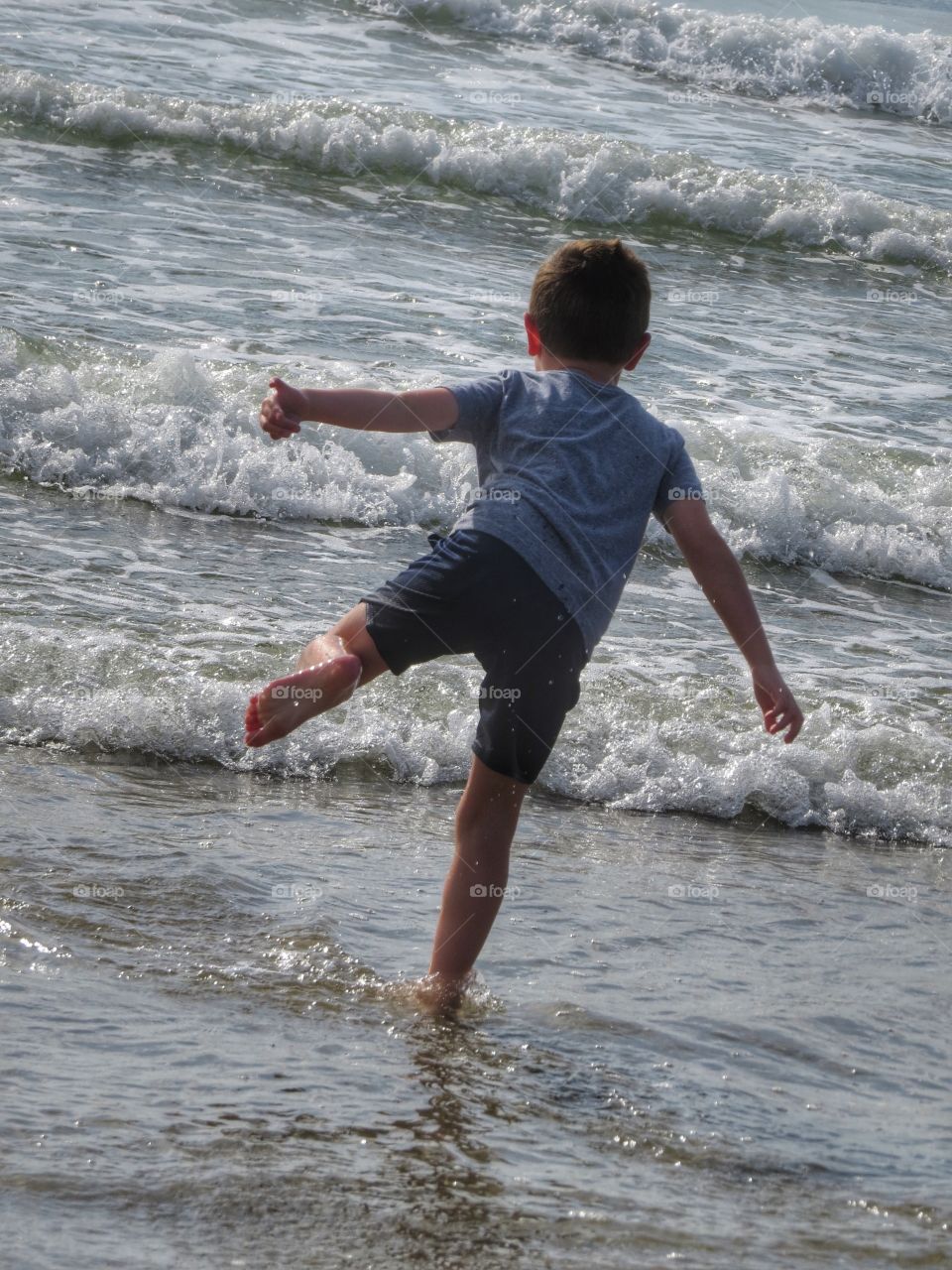 Little boy playing in the ocean.