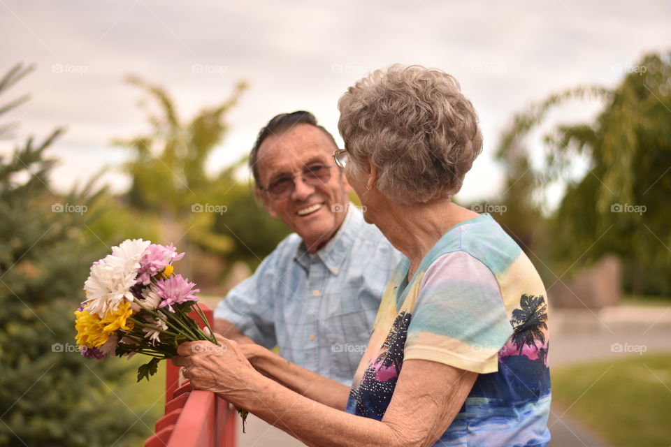 Close-up of senior couple with flower bouquet at outdoors
