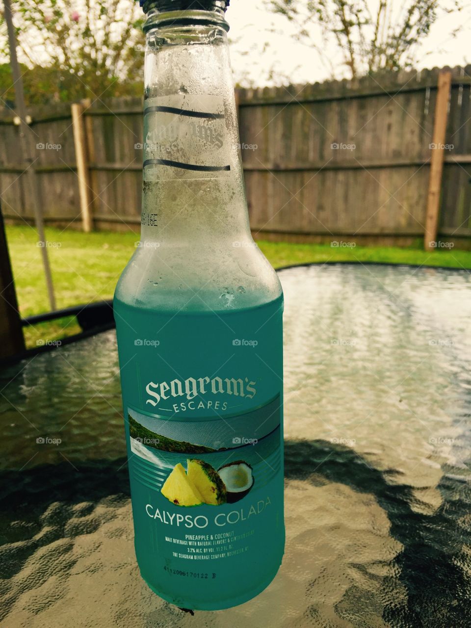 Refreshing drink in glass bottle on glass table on a hot summer day in the south. 