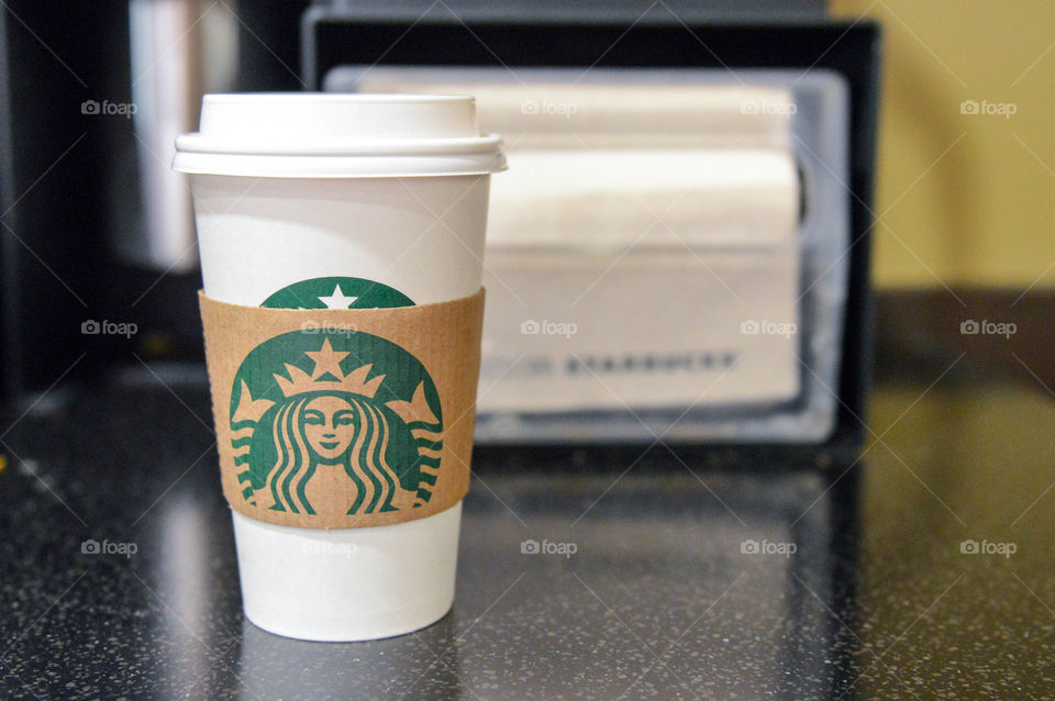 A cup of coffee sitting on a counter at a Starbucks store