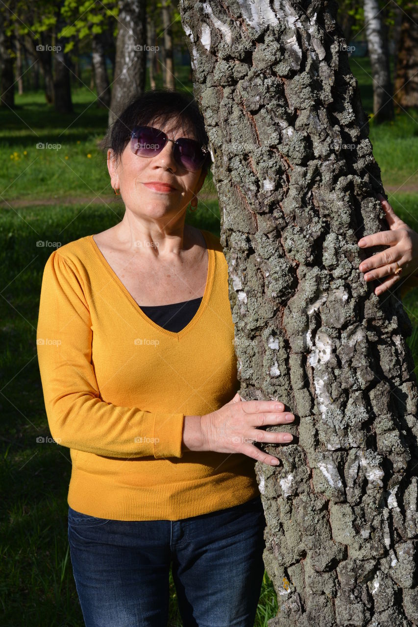 woman relaxing on a birch tree energy nature in the light summer time