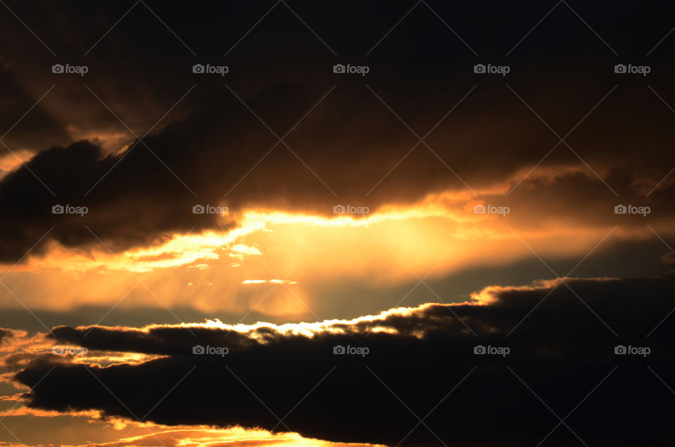 A fire burned cloudscape  in the distance  reels in the sun in the evening skies that sit above Newark Airport.