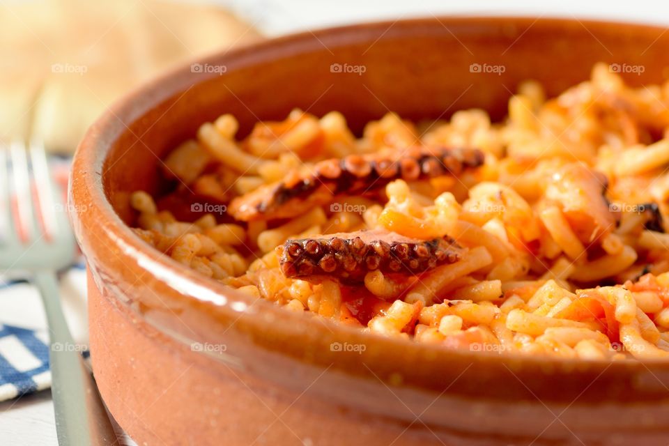 Close-up of octopus in tomato sauce with pasta