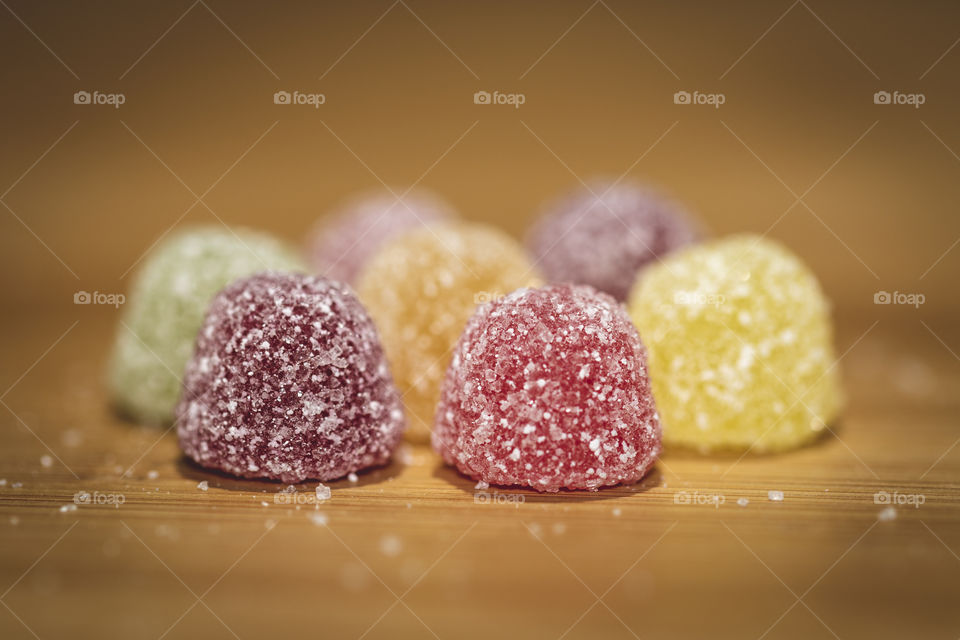 A macro portrait of some candy with sugar on top on a wooden table. very delicious but unhealthy.