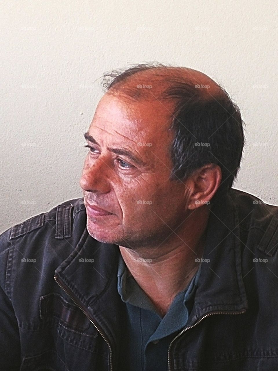 Mature man sitting against wall