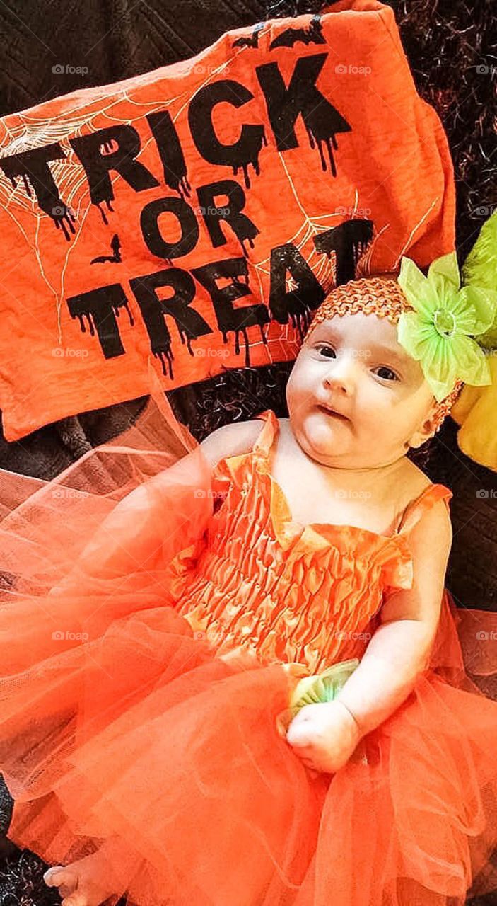 Cute baby girl wearing orange dress