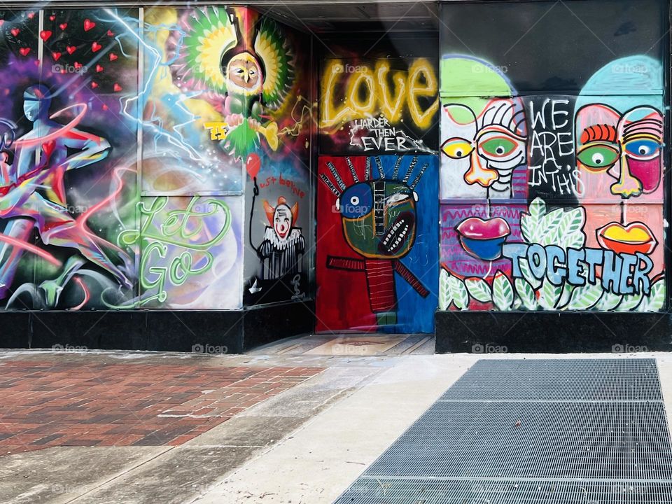 Love graffiti in downtown Birmingham. Brightly colored mural on window glass by city sidewalk.