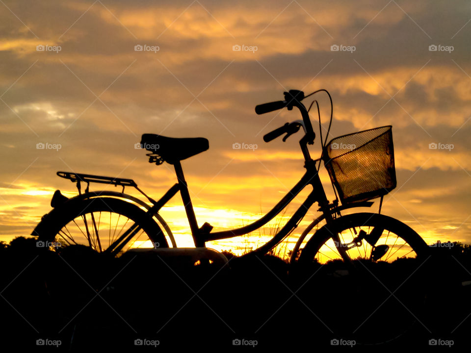 Silhouettes of a bicycle during sunset