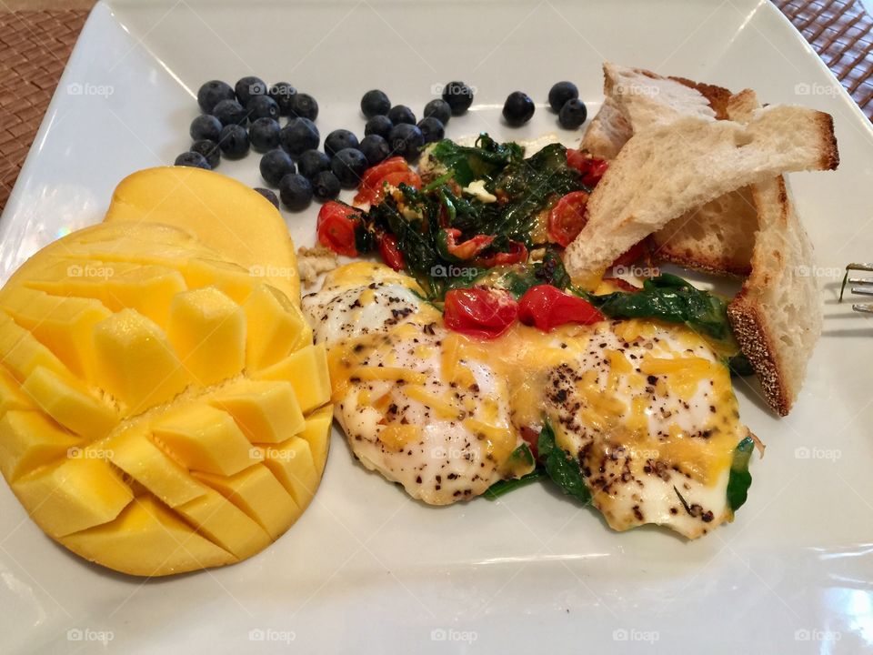 Pouch Eggs on a
Tomato spinach red bell pepper Cheese Omelette. Enjoyed with fresh
Mango, Blueberries & light Toast 