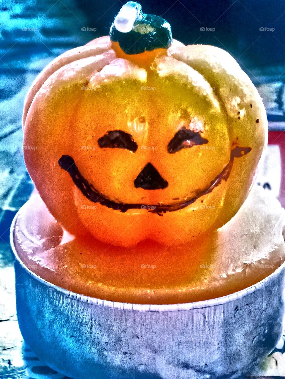 This is A candle that's shaped into a cute pumpkin with an eye, nose and mouth during Halloween day.