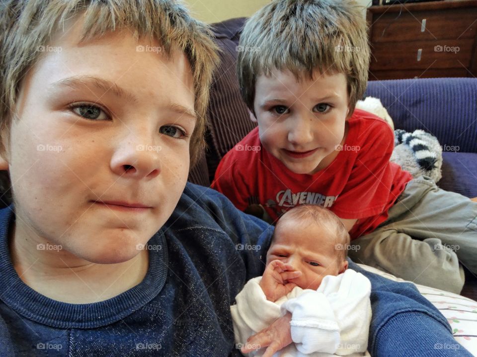 Brothers With Their Newborn Infant Sister
