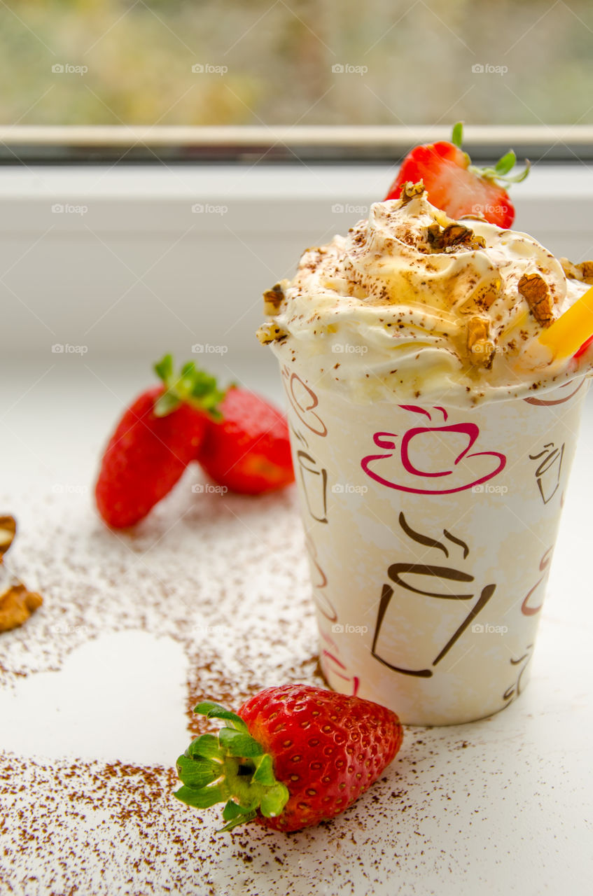 Morning coffee with cream, nuts and strawberries