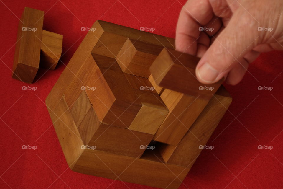 Hand making wooden cube from blocks