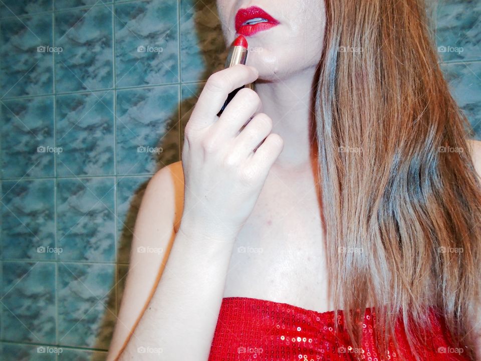 Attractive woman applying red lipstick