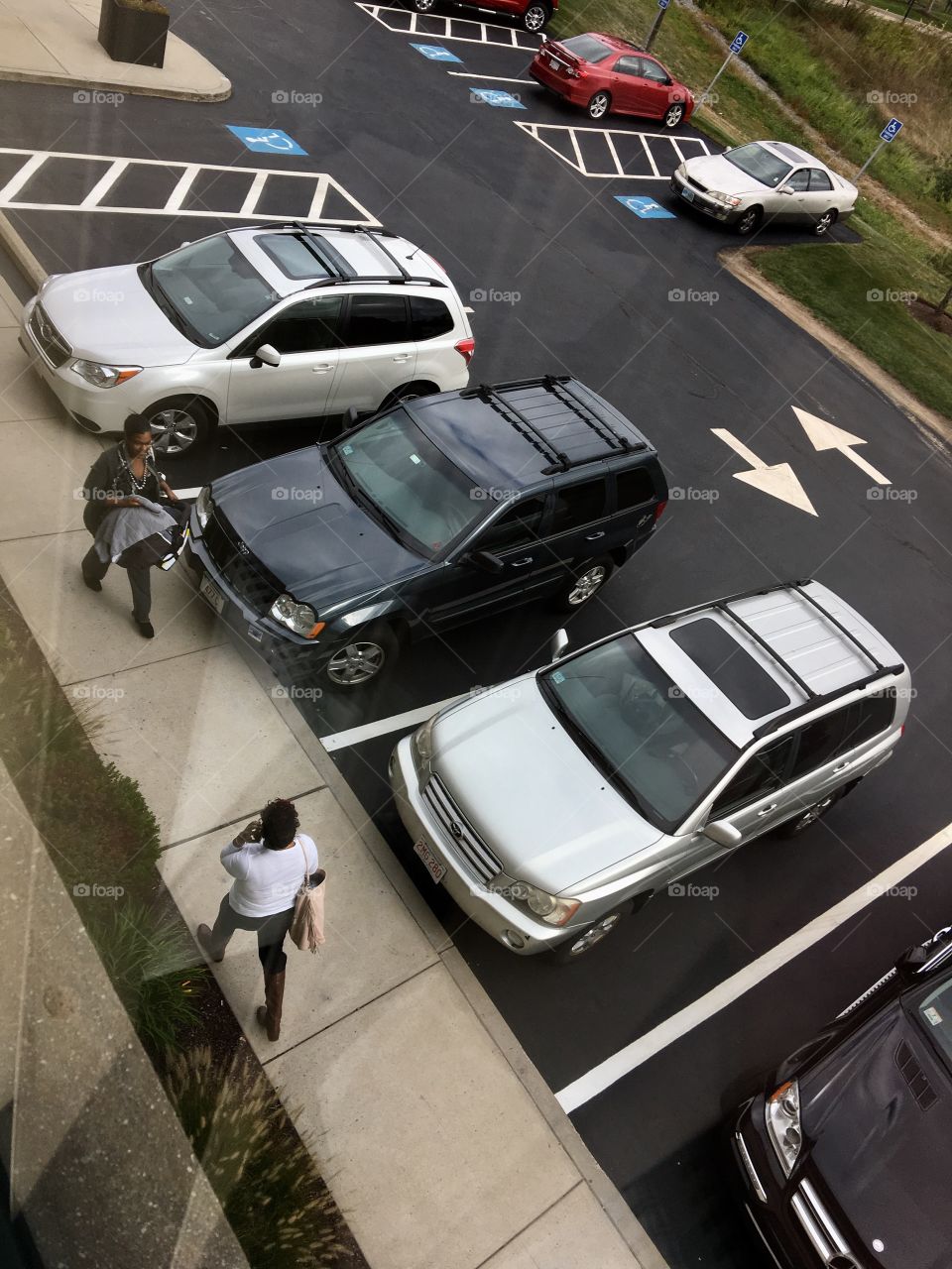 Doctors office parking lot, patients walking.