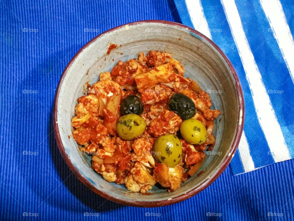 Cauliflower with olives and tomatoes in a bowl