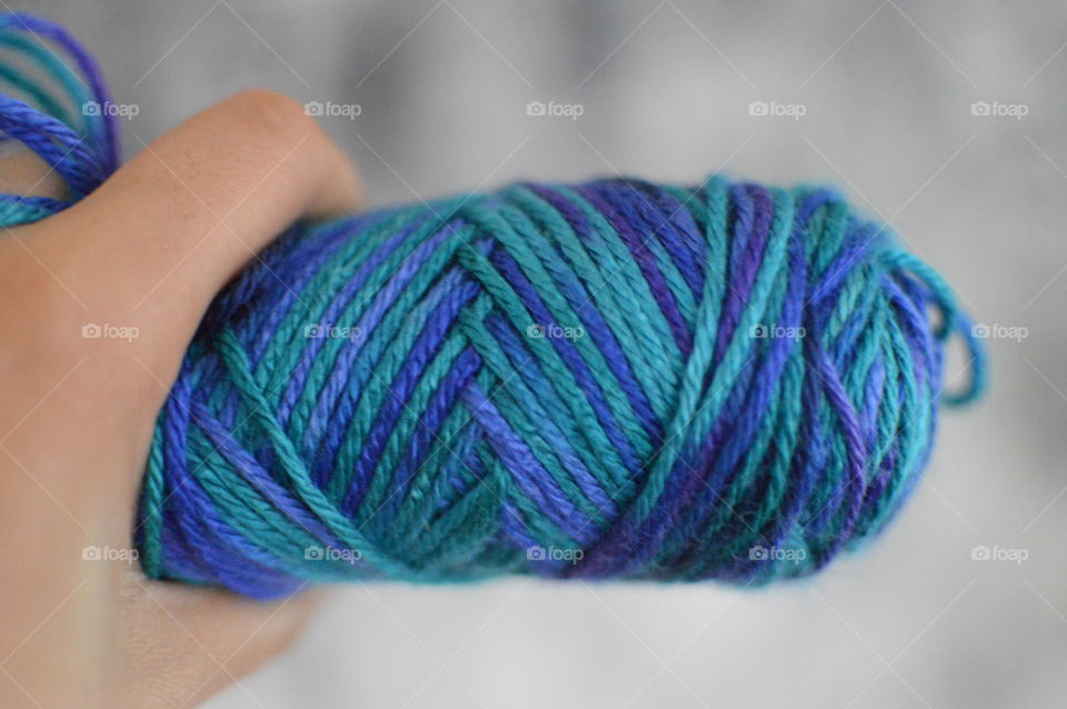 A person holding blue wool