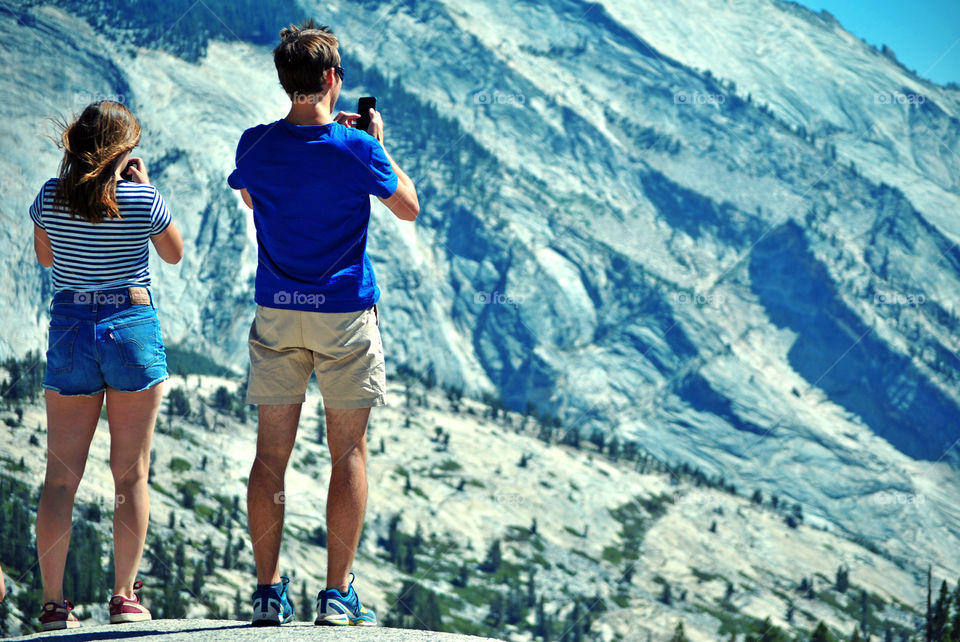 Tourists taking a photo of the beautiful canyon view using their mobile camera