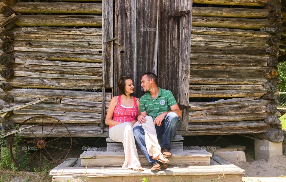 Two couple sitting near old house