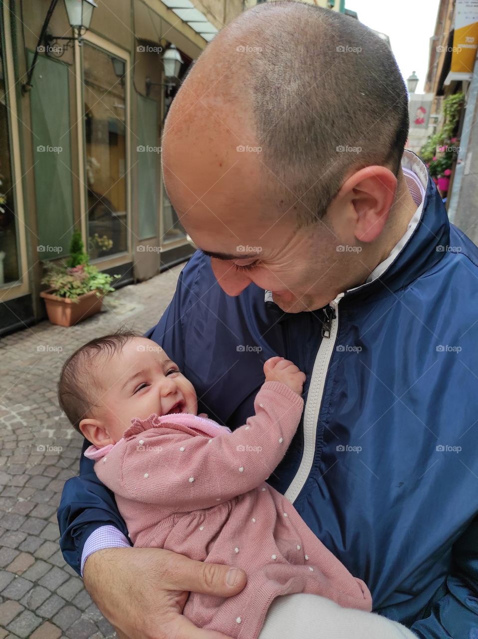 little girl in dad's arms smiling