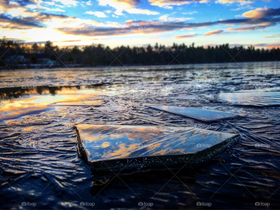 View of frozen pond with dramatic sky