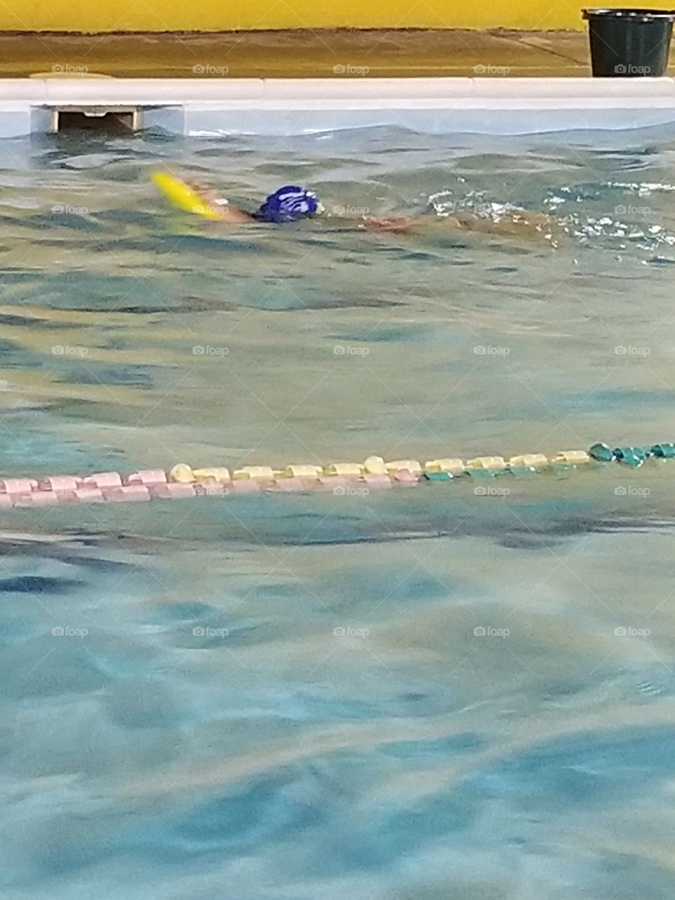 girl swimming with board to practice swimming skill