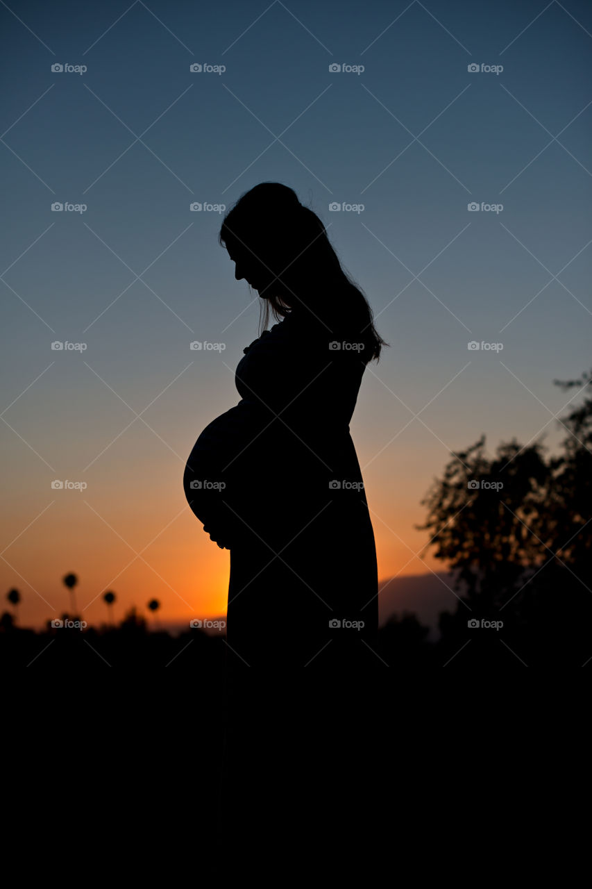 Mother to be waiting in the sunset 