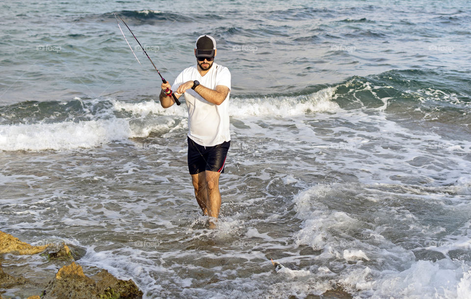 Fisherman hooks a fish at the seashore