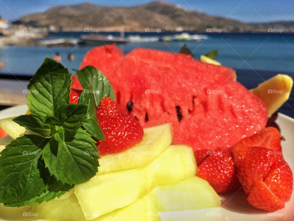Mixed summer tasty fruits. Mixed summer tasty food on the blue sea background 