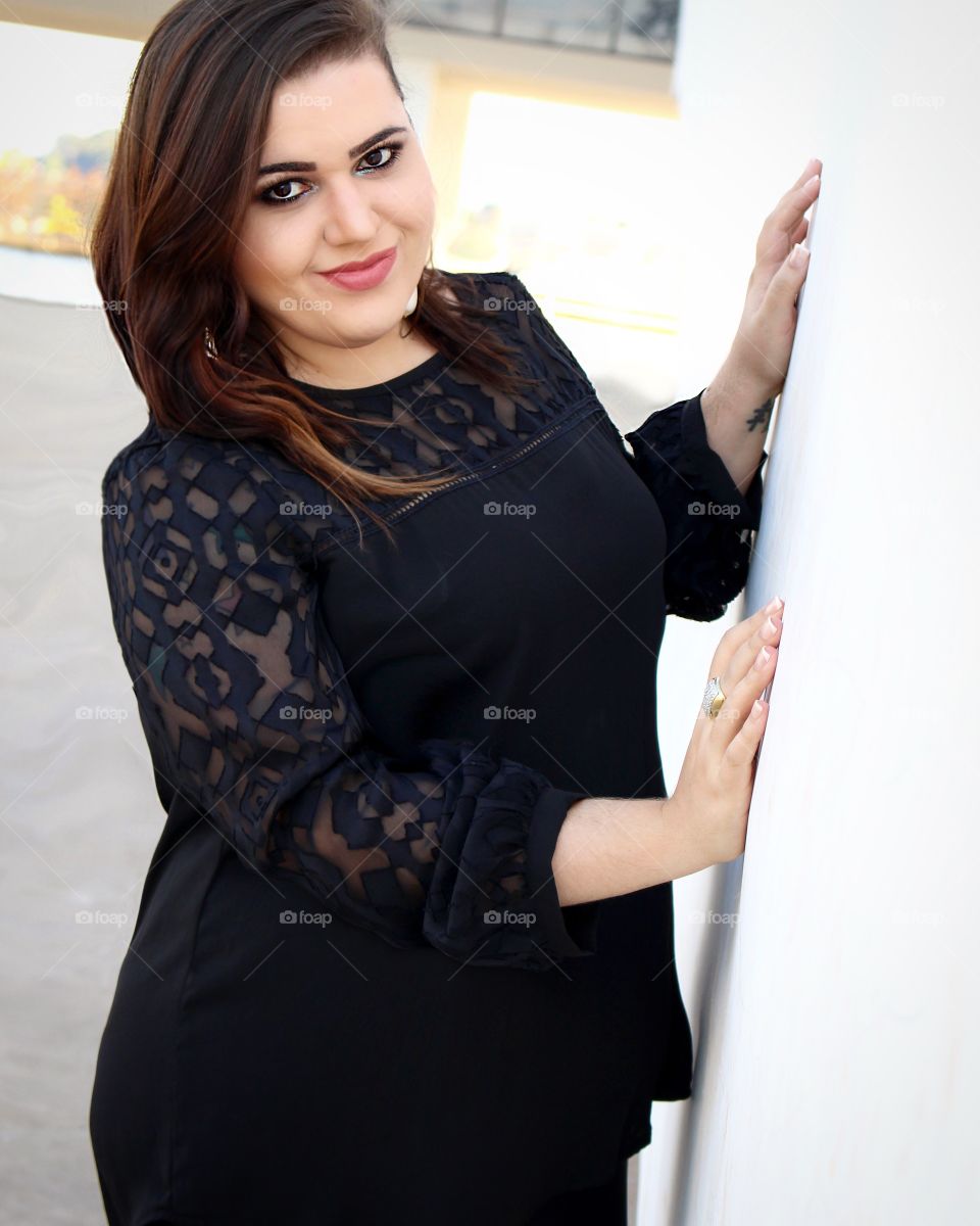 Pretty smiling woman posing in black dress