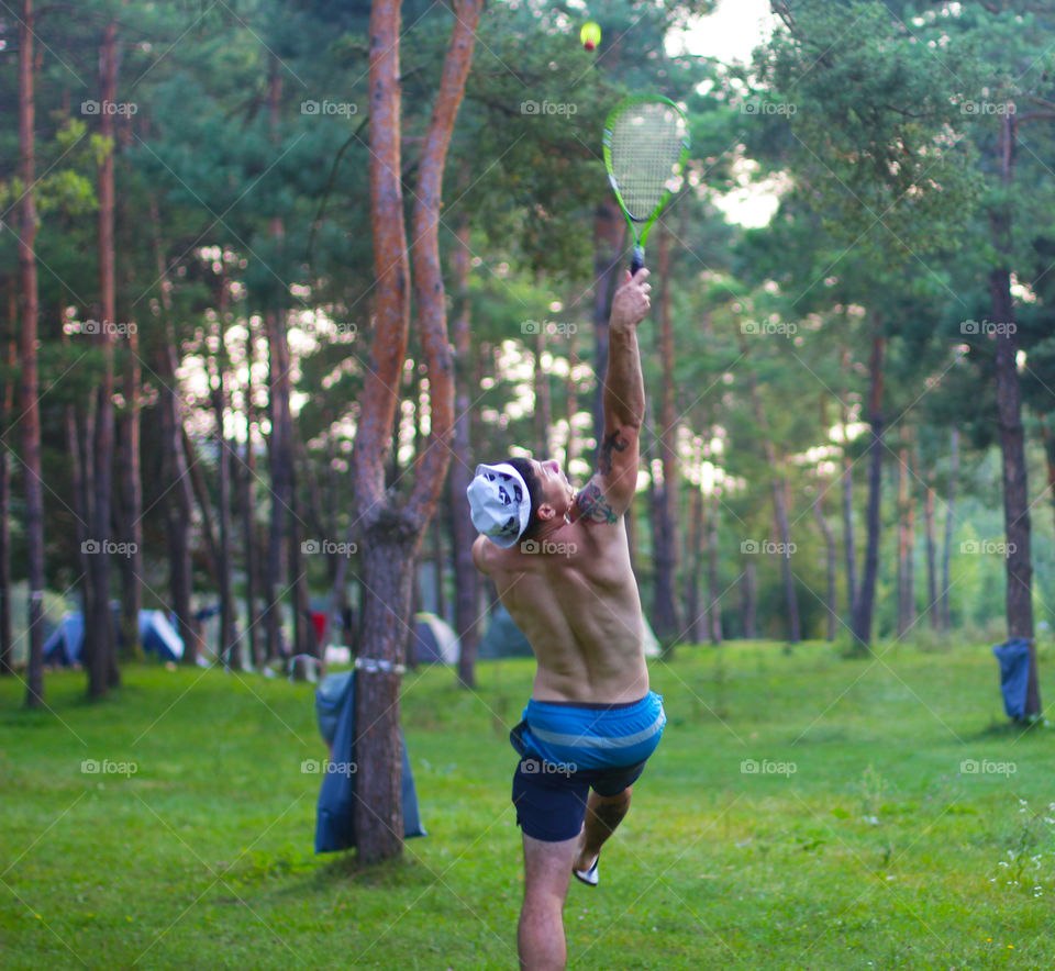 Man playing badminton In the pine forest