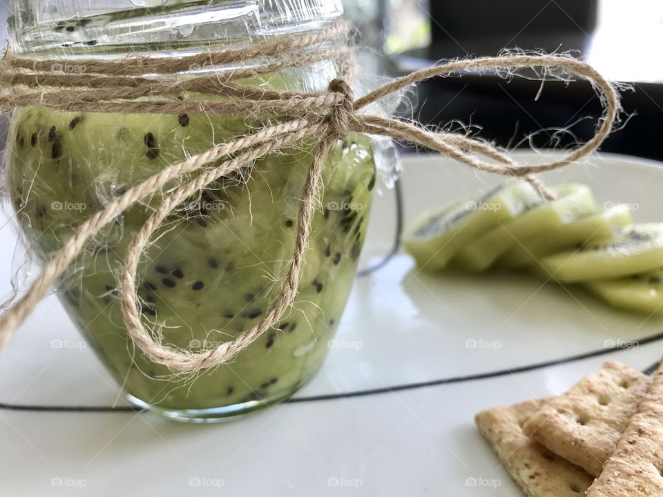 Homemade Kiwi jam and crackers on a plate 