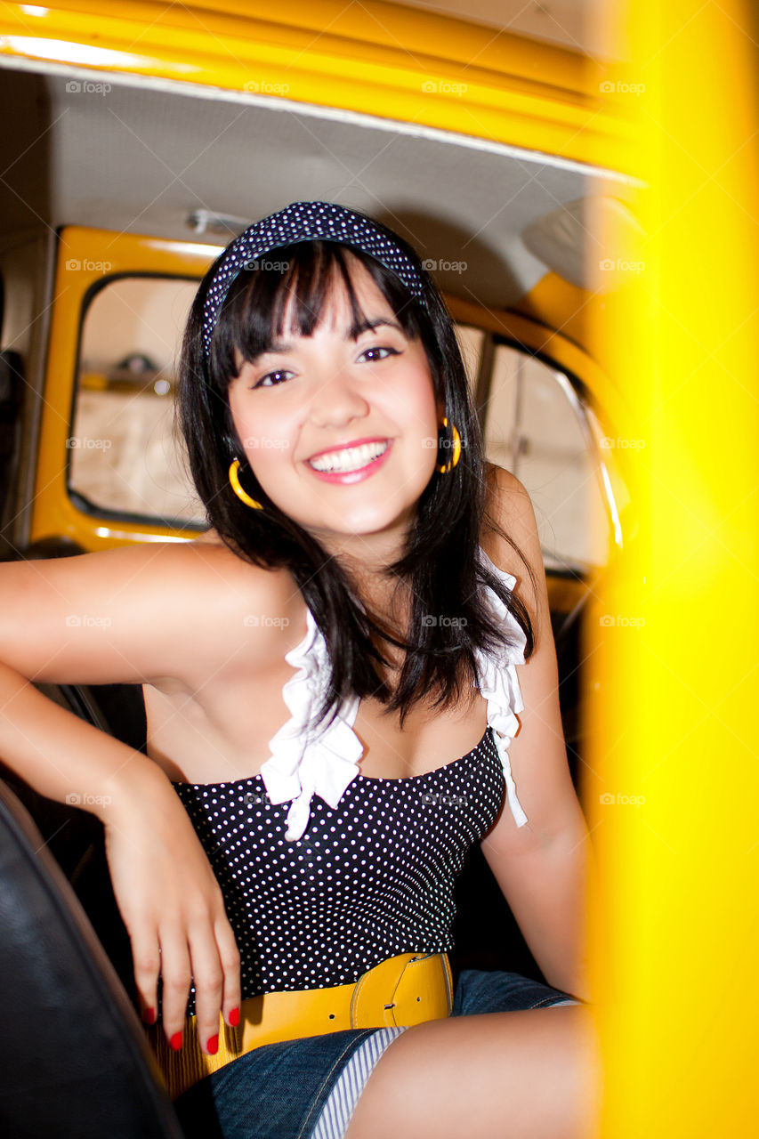 Smiling teenage girl sitting in car