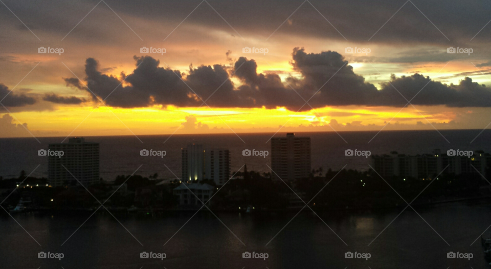 Sun setting on ocean and Boca Raton, Fl skyline