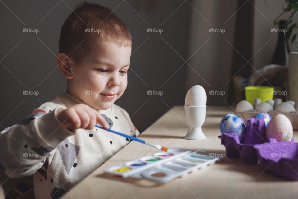 Toddler boy coloring easter eggs
