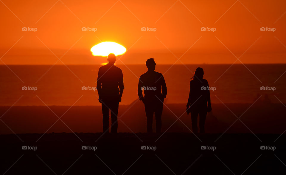 Silhouette of people at beach during sunset