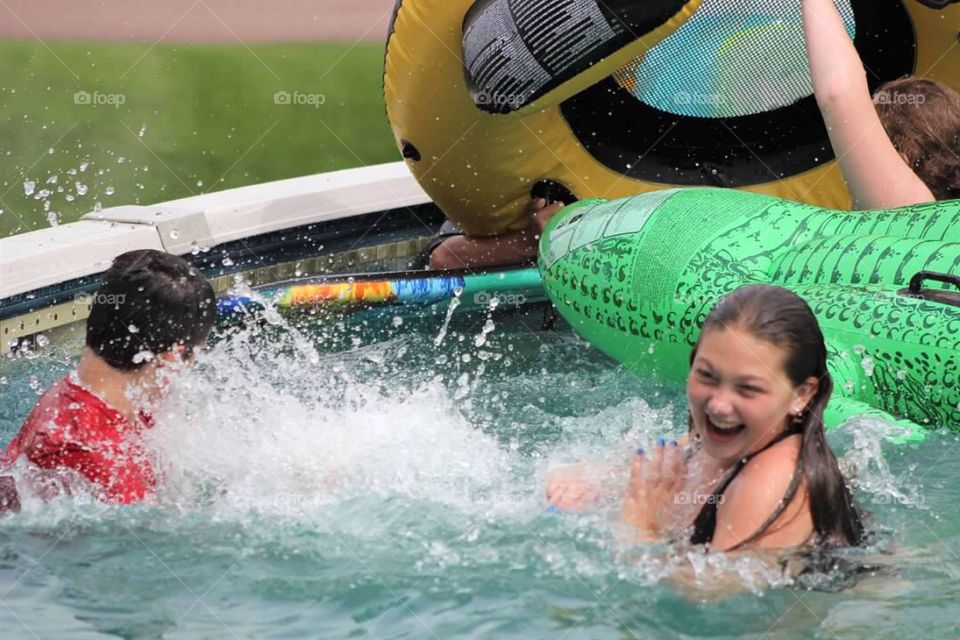 Children having a splash fight in the pool. 