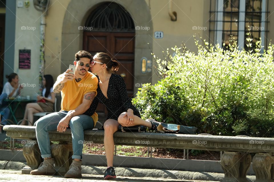young couple sitting enjoying the Italian sun