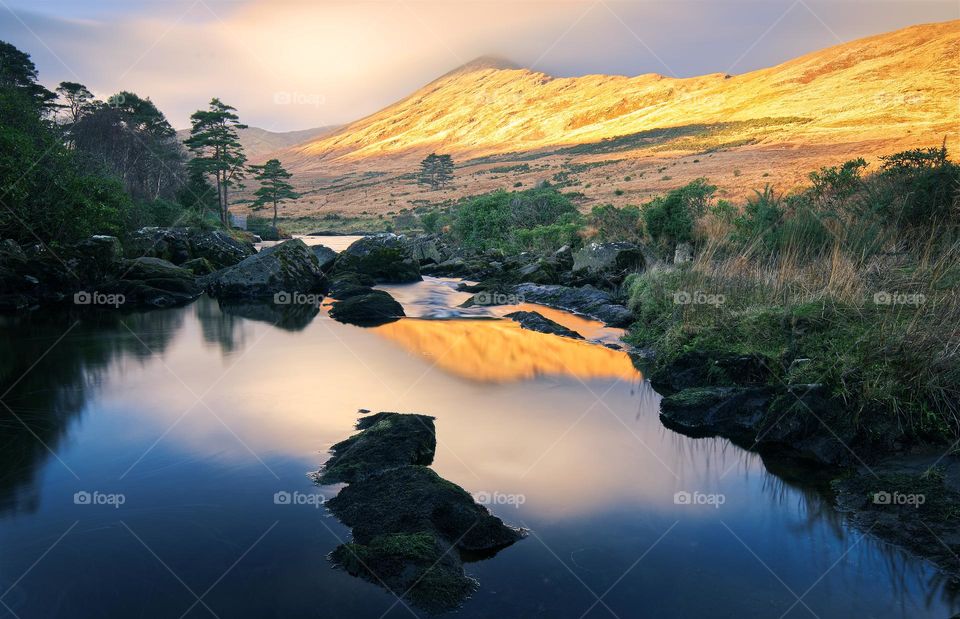 Beautiful morning landscape scenery with mountains illuminated with morning light reflected in river Erriff at Aesleagh, county Mayo, Ireland