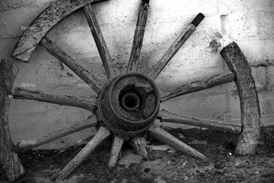old wagon wheel against a wall