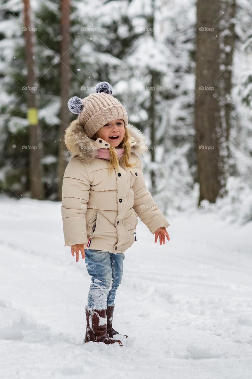 Lifestyle portrait of unhappy Caucasian little girl crying outdoor 