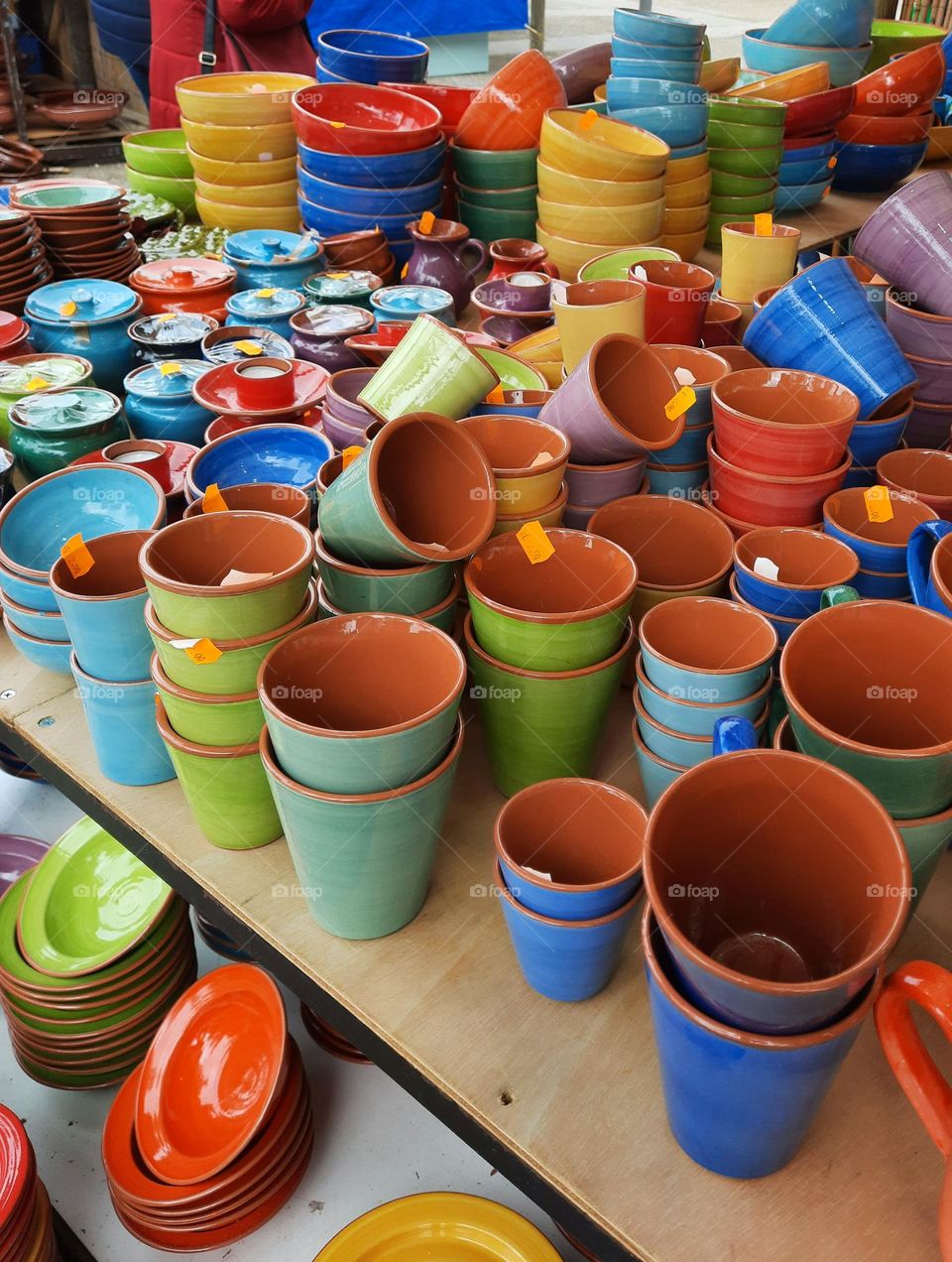 Set of colourful handmade ceramic tableware objects, displayed for sale at a stand in a local traditional market in Marratxi (Majorca)