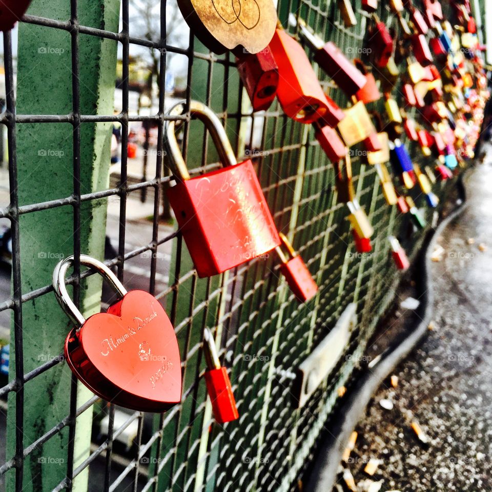 Love heart shaped locks by the grilles of the bridge in Hamburg 
