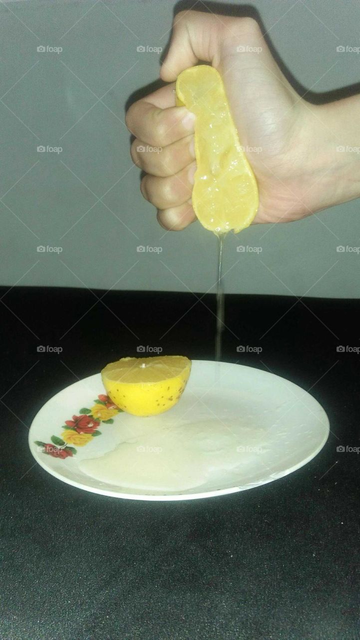 Small hand squeezing a lemon.